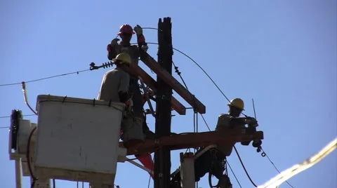 3 construction guys working on an electric pole Stock Footage 64980689