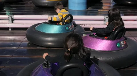 3 CUTE HISPANIC SIBLINGS RIDE BUMPER CARS AT AMUSEMENT PARK. Stock Footage 63319695