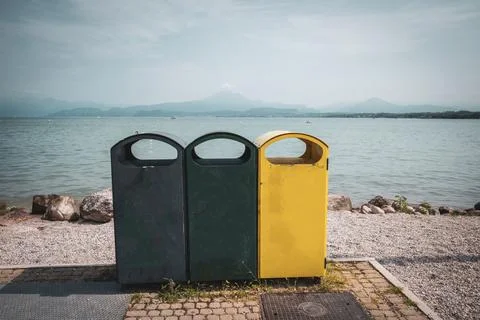 3 different garbage cans to separate garbage stand on the shore of Garda Lake Stock Photos