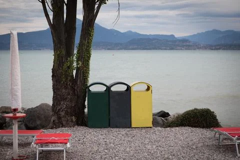 3 different garbage cans to separate garbage stand on the shore of Garda Lake Stock Photos