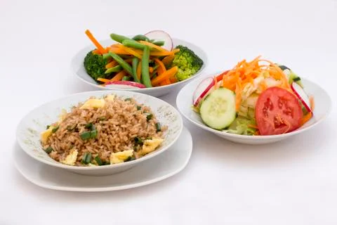 3 different types of salads: fried rice (arroz chaufa), fresh salad (tomatoes, s Stock Photos