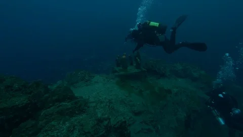3 divers in front of the crib at the bottom of the lake, San Domenico Lake Stock Footage 104597543