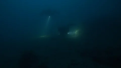 3 divers light up the rocky seabed, Argentario, Mediterranean sea, Italy Stock Footage 108742621