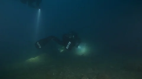 3 divers with torch swims from behind at the seabed,Argentario,Mediterranean sea Stock Footage 108733960