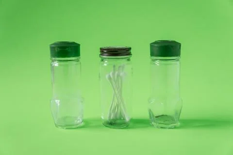 3 Empty glass spice jars on lime green background with blank empty room space Stock Photos