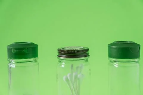 3 Empty glass spice jars on lime green background with blank empty room space Stock Photos