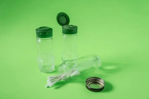 3 Empty glass spice jars on lime green background with blank empty room space Stock Photos