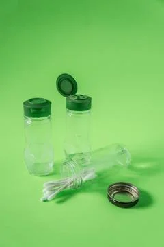 3 Empty glass spice jars on lime green background with blank empty room space Stock Photos