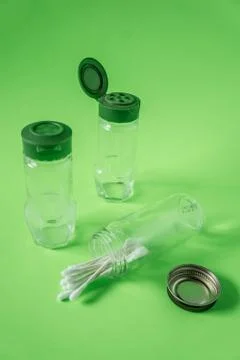 3 Empty glass spice jars on lime green background with blank empty room space Stock Photos