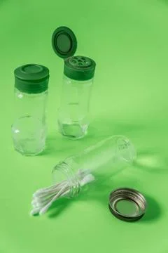 3 Empty glass spice jars on lime green background with blank empty room space Stock Photos