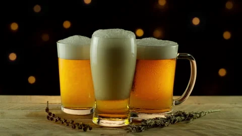 3 Glasses of Beer Pouring on Rustic Wood Table Stock Footage 141537719