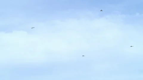 3 Helicopters wit biplane flying by with banner Stock Footage 132017949