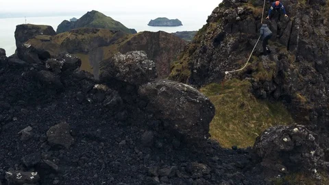 3 Hikers Go Down From A Cliff In Vestmannaeyjar, Iceland In A Windy Day Stock Footage 108753641