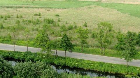 3 lone cyclist on an empty road. country road. field, trees, river Vídeos de archivo 267402858