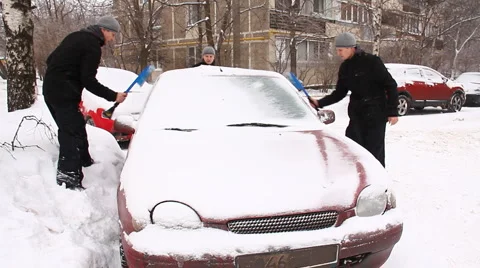 3 man cleans a car from the snow Stock Footage 1002260