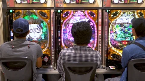 3 man sitting in a pachinko parlor in Japan, with their backs facing the camera. Stock Footage