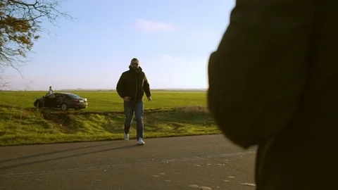 3 men preparing to shoot aerial scene with car beautiful countryside at sunset Stock Footage
