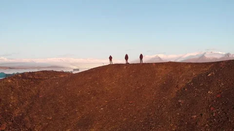 3 men standing on a hill in front of icebergs Stock Footage 158748018