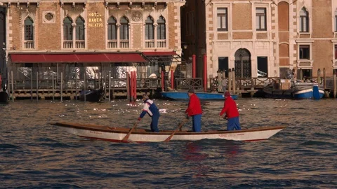 3 men standing up paddling a boat along the Grande Canal in Venice Видео 128317771