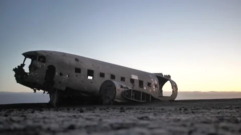 3 men walking in front of abandoned plane in iceland Stock Footage 158746641