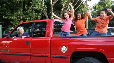 3 Multi racial kids on bed of red pickup truck having fun, mom looks on Video stock 45525148