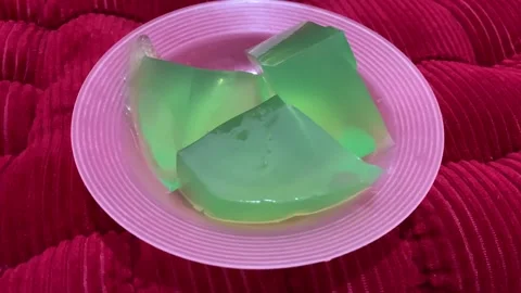 3 pieces of green pudding on a pink plate Stock Footage 284000817