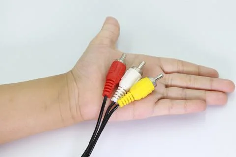 3 RCA Jack Plug Adapter Audio in kid hand isolated on white background. Stock Photos