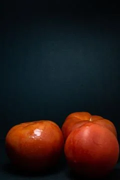 3 red tomatoes with dark background Stock Illustration