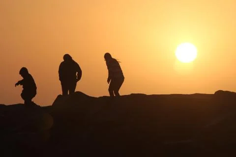 3 on rocks sunset Stock Photos