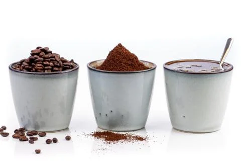 3 rustic coffee cups filled with hot coffee, beans, and ground coffee. White Foto stock