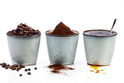 3 rustic coffee cups filled with hot coffee, beans, and ground coffee. White Stock Photos