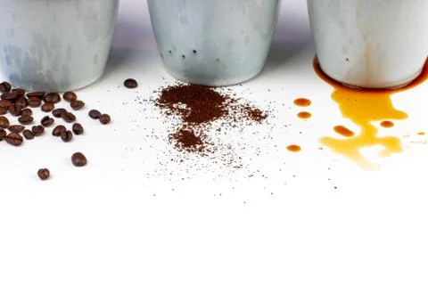 3 rustic coffee cups filled with hot coffee, beans, and ground coffee. White Stock Photos