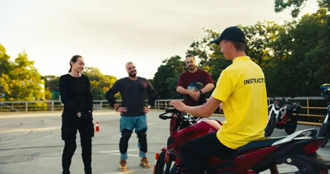 3 students at school interact with a professional motorcycle driver. Driving Stock Footage 249606527