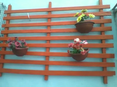 3 vases with plastic flowers hanging on the wood near the wall Stock Footage 166432048