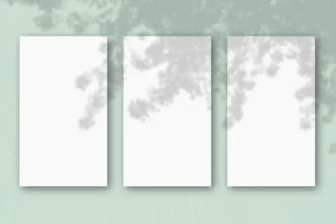 3 vertical sheets of textured white paper on light green table background. Mo Stock Illustration