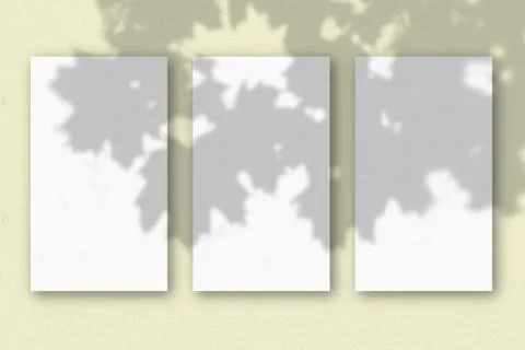 3 vertical sheets of textured white paper on soft yellow table background. Mo Stock Illustration