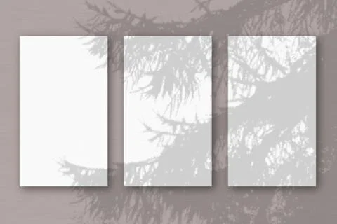 3 vertical sheets of textured white paper on soft blue table background. Mock Stock Photos