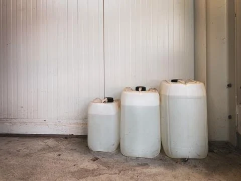 3 white canisters of different sizes are filled with liquid Stock Photos