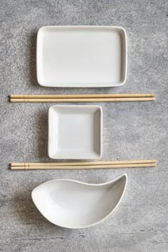 3 white empty plates of different shapes and bamboo chopsticks Stock Photos