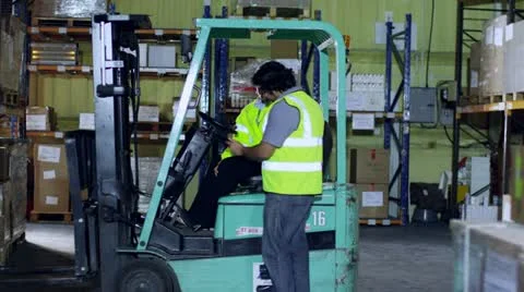 3 workers are checking stocks and inventory within a warehouse Stock Footage