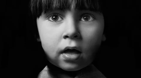 3 year old boy looking curiously at the camera. monochrome portrait on solid  Stock Photos