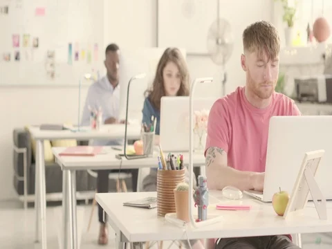 3 Young adults working in startup office. Rack focus Stock Footage 72852289