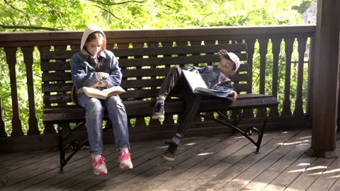 30 girl reads a book, the boy is tired and lies on a bench with a book Stock Footage 268432453