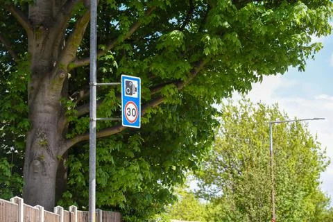 30 mph speed limit warning of traffic camera on city street Stock Photos