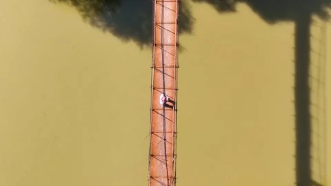 30-Top Down Drone Shot of Person Operating Drone on Narrow Metal Bridge Over Stock Footage 336716798