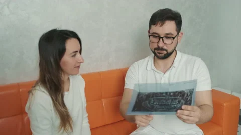 A 30-year-old dentist man sitting talking to a Caucasian patient on the couch Stock Footage 150680486