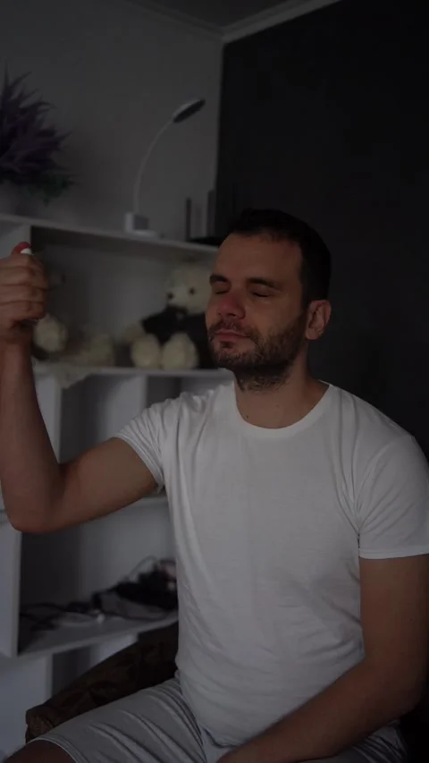 30-year-old man applies spray tonic to his skin Stock Footage 294524767