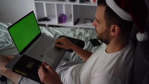 A 30-year-old man with a Bible attends an online church service, talks with.. Stock Footage 294520912