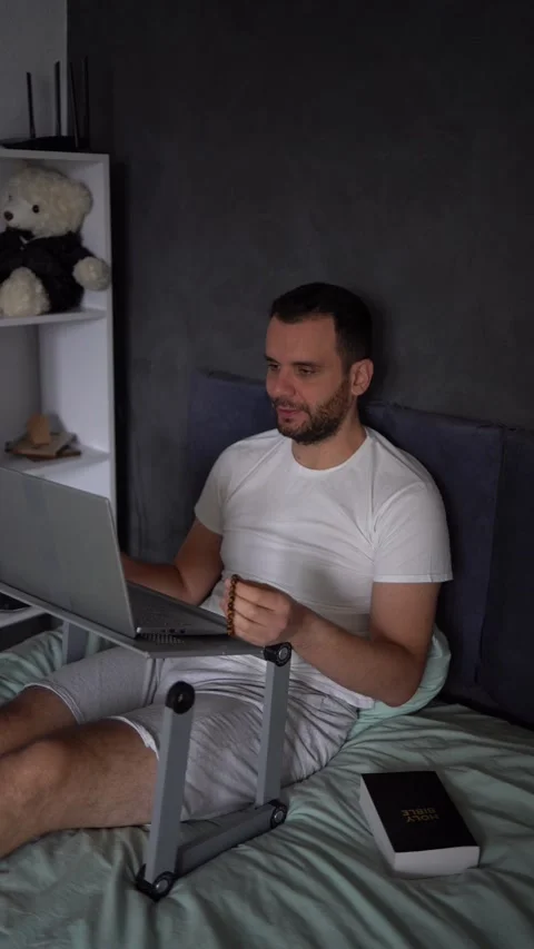 30-year-old man with a Bible attends an online church service, talks with t.. Stock Footage 294524342