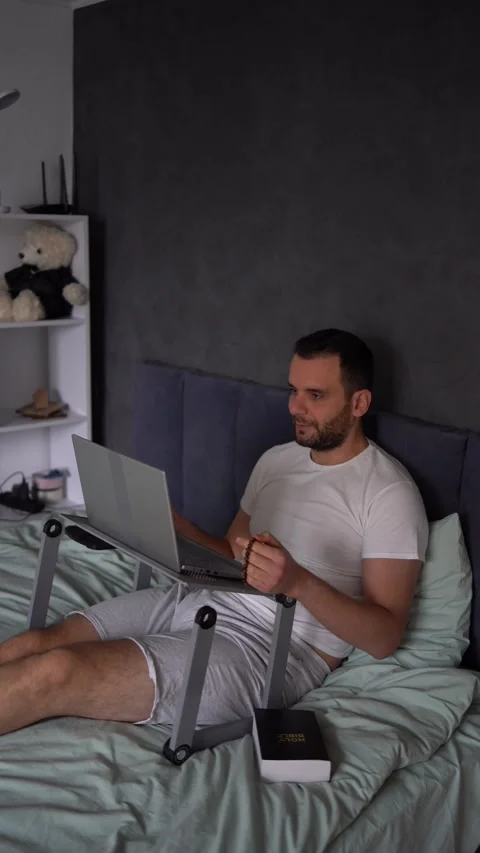 30-year-old man with a Bible attends an online church service, talks with t.. Stock Footage 294524516